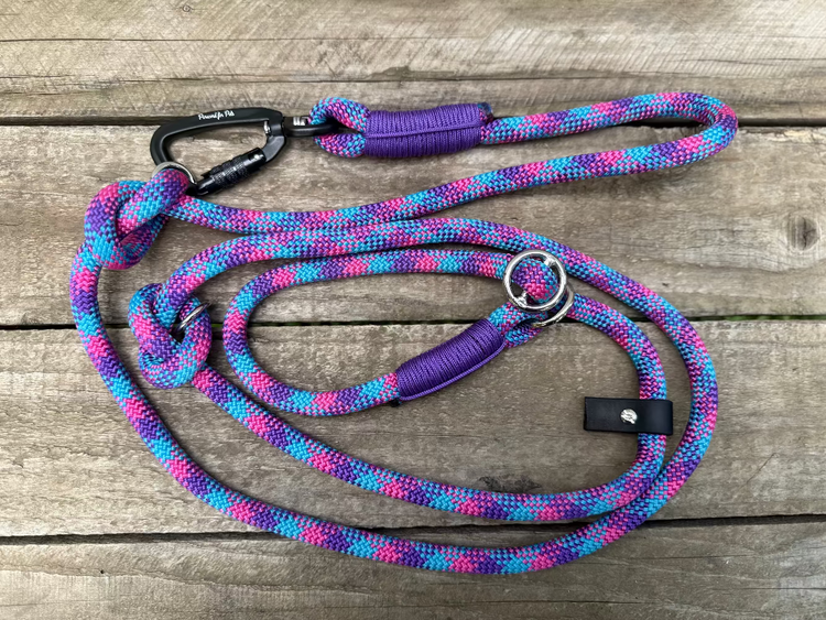 Colorful braided dog leash with carabiner on a wooden surface